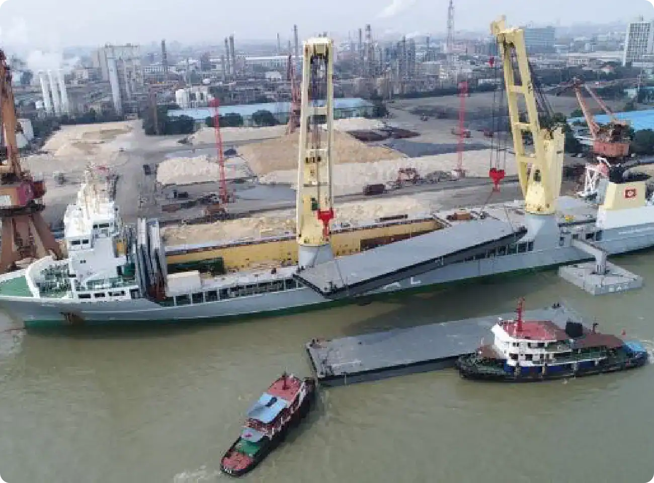 Trident Pontoons vessel being delivered by sea aboard a cargo ship and docked with tugboats