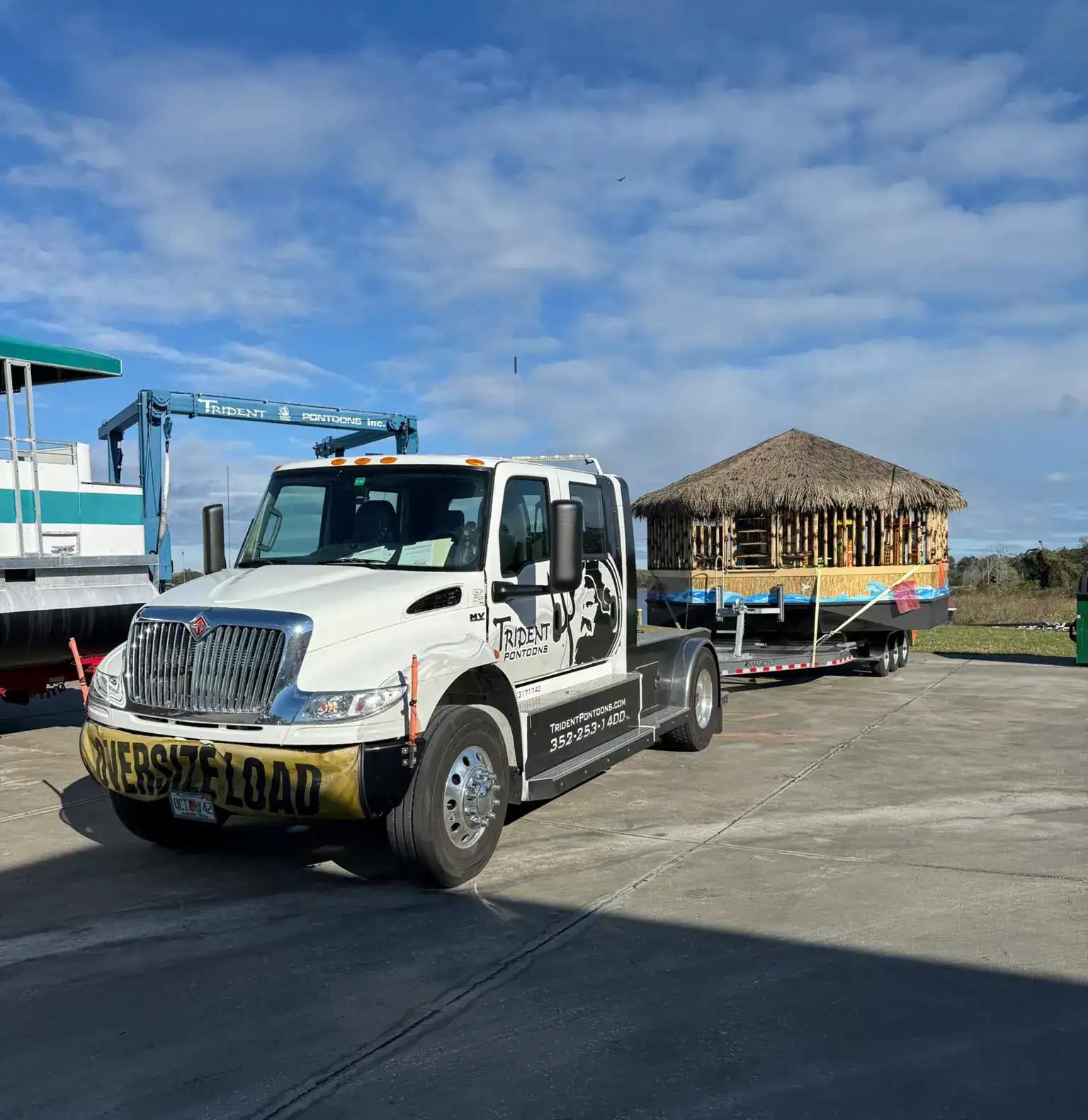 Trident Pontoons truck transporting custom tiki hut pontoon boat as oversized load delivery
